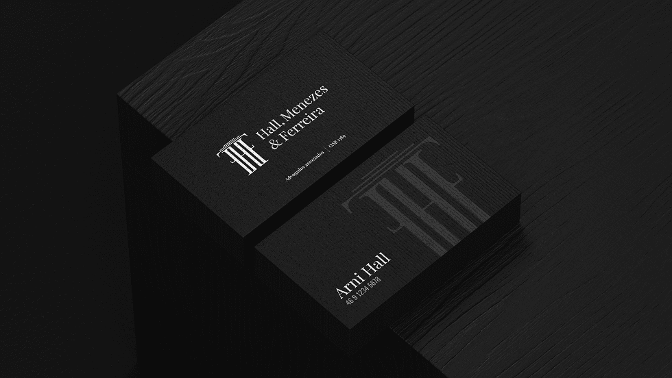 Business cards in black, carrying the monogram and the firm's name